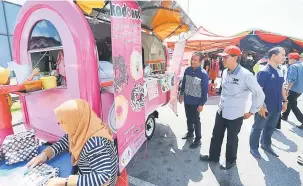  ??  ?? LAWAT: R.Affendi bersama Paza melawat pameran trak makanan semasa program ‘Business On Truck’ Peringkat Negeri Sarawak di Kuching, semalam.