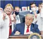  ??  ?? President Donald Trump signs an executive order on lowering drug prices on Friday