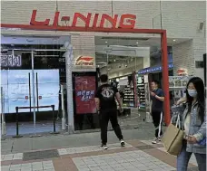  ?? /Reuters ?? Fit for purpose: People walk past a store of Chinese sports products brand Li Ning in Beijing, China.