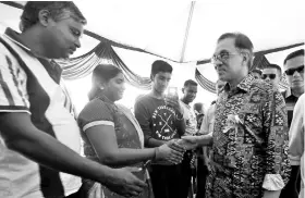  ??  ?? Anwar (right) shaking hands with the crowd after attending the Port Dickson Ponggal Festival 2019 at Bandar Springhill yesterday. - Bernama photo