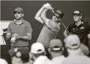  ?? Jon Shapley / Staff photograph­er ?? Phil Mickelson, center, who shot a 76, tees off on No. 13 while Jason Day, left, and Hovland wait. Mickelson had two double bogeys and no birdies.