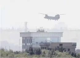  ?? RAHMAT GUL/AP ?? A U.S. Chinook helicopter Sunday flies near the U.S. Embassy in Kabul. U.S. reports of gunfire at the airport threatened to shut down one of the last avenues of escape.