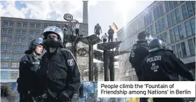  ??  ?? People climb the ‘Fountain of Friendship among Nations’ in Berlin