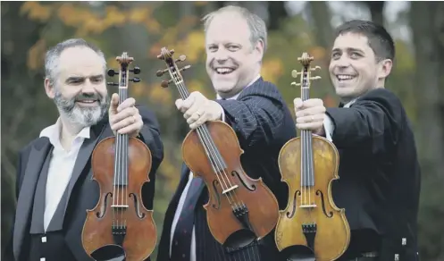  ??  ?? 0 From left, violin-maker Steve Burnett with the Siegfried Sassoon violin, historian Neil Mclennan, with the Robert Graves violin and fiddle player Thoren Ferguson holding the Wilfred Owen violin at Baberton Golf Club in Edinburgh