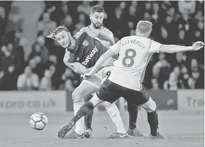  ?? — Gambar Reuters ?? KAWAL KETAT: Carroll (kiri) diasak oleh dua pemain Watford ketika bersaing pada aksi liga di Vicarage Road, Watford pada Ahad lepas.