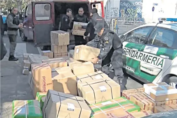  ??  ?? Secuestro. Gendarmerí­a y Policía recuperan cajas de golosinas y lencería robadas a un repartidor, en Capital Federal, el mes pasado.