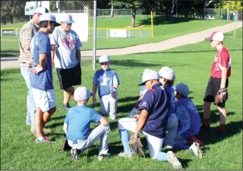  ?? MIKE BUSH/NEWS-SENTINEL ?? Above: Members of the Lodi 9 and under all-star baseball team talk with their coaches before the start of Tuesday's practice at Salas Park. Below: Left fielder Austin Job catches a fly ball during Tuesday's practice.