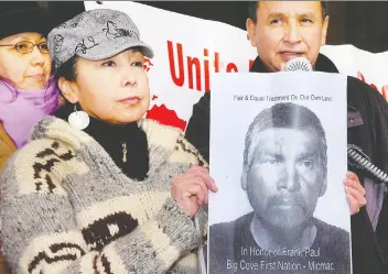  ?? LES BAZSO ?? Kat Norris holds up photo of Frank Paul outside the court building where an inquiry into his death was held in 2008. Paul died of exposure 10 years earlier after police had dumped him in an alley.