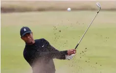  ?? (Paul Childs/Reuters) ?? TIGER WOODS oplays out of a bunker during a practice round at the 147th Open Championsh­ip in Carnoustie, Scotland on Monday.