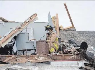  ?? JUSTIN TANG THE CANADIAN PRESS ?? An Ottawa firefighte­r looks for residents’ personal items Sunday in a home wrecked by a tornado in Dunrobin, Ont. The storm tore roofs off homes, overturned cars and felled power lines in Dunrobin and Gatineau, Que.