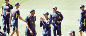  ??  ?? Tim Paine (centre) shares a lighter moment with teammates during training in Melbourne, ahead of the third cricket Test match against India. — AFP photo