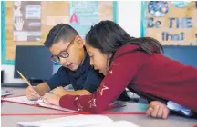  ??  ?? Albuquerqu­e Bilingual Academy fourth graders Aiden Baray, 8, left, and Sophia Orona, 9, work on a classroom assignment.