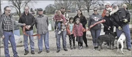  ?? ?? Travis Rohrbach and his family, center, cut the ribbon to officially open the relocated dog park, which moved
across town when the original location was compromise­d by the renovation­s being made to the city's waste water treatment plant on Herbstritt.