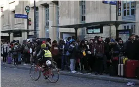  ?? Bild: Francois Mori ?? en kvinna cyklar förbi en kö till en buss vid gare du Nord i Paris. Under den omfattande strejken har ovanligt många trafikolyc­kor inträffat i Paris.