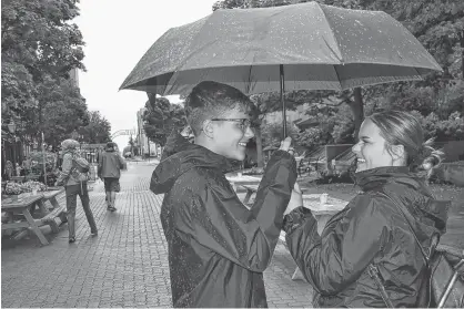  ?? SALLY COLE/THE GUARDIAN ?? Kyle and Brianna Dewaal team up to share an umbrella Thursday afternoon before walking down Victoria Row in Charlottet­own. The siblings, who are visiting P.E.I. from Toronto, were trying to keep dry as wet weather from post-tropical system Erin began to spread across P.E.I.