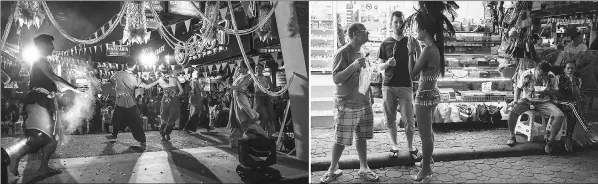  ??  ?? (Left) Performers dancing during a staged event used to highlight a push by the city of Pattaya to promote safety in the area. • (Right) Two foreign tourists (left) standing in front of a stall selling handbags in Walking Street in Pattaya. — AFP photos