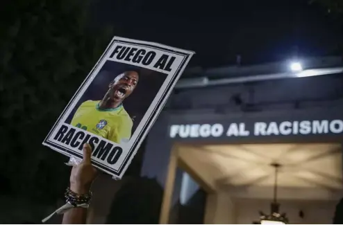  ?? ?? A protester holds up a photo of Brazilian soccer star Vinicius Jr and a message that reads in Portuguese; "Fight racism". Tuane Fernandes/Copyright 2023 The AP. All rights reserved.