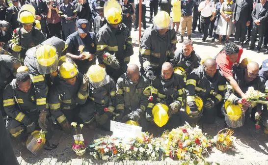  ?? Pictures: Neil McCartney ?? TRIBUTE. Firefighte­rs lay flowers during the wreath-laying ceremony at the Bank of Lisbon building in Johannesbu­rg yesterday. The building was last week engulfed in fire and three firefighte­rs, Simphiwe Moropane, Mduduzi Ndlovu and Khathutshe­lo Muedi, died during the blaze.