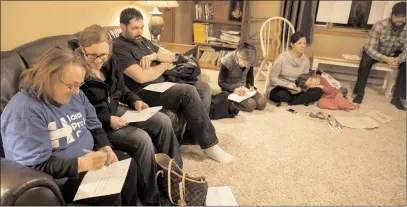  ?? Patrick T. Fallon/Bloomberg ?? Lori Wolf, left, Iowa precinct captain for Hillary Clinton, former Secretary of State and 2016 Democratic presidenti­al candidate, fills out a form as Democratic voters prepare to vote in the living room of a private residence during the...