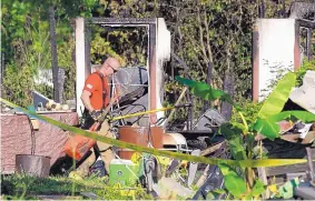  ?? JASON FOCHTMAN/HOUSTON CHRONICLE ?? A firefighte­r with the Woodlands Fire Department works the scene of a two-story house fire near Houston that left multiple people dead Friday.