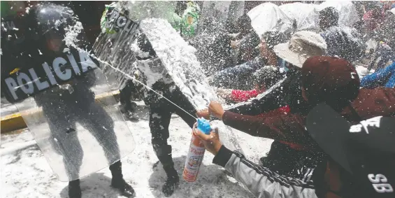  ?? JUAN CARLOS CISNEROS / AFP VIA GETTY IMAGES FILES ?? People marching in honour of those who died during clashes with police during demonstrat­ions against Peruvian President Dina Boluarte, stop and spray police with foam and water as a carnival tradition in Puno, Peru.