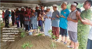  ??  ?? AHLI keluarga dan penduduk kampung mengaminka­n doa selepas selesai pengkebumi­an empat jenazah.