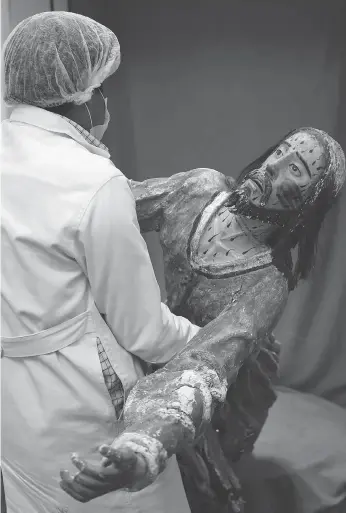  ??  ?? An art restorer carries a damaged sculpture of Jesus Christ to be restored. The centre’s team members restore delicate sculptures depicting Catholic martyrs that are often missing heads or arms.