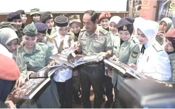  ??  ?? Zulkiple (centre) together with army female officers and personnel browse through ‘Srikandi Tentera Darat’ books during the launching. — Bernama photo