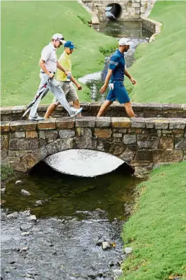  ??  ?? Getting ready: (From right) Dustin Johnson, Jordan Spieth and coach Cam McCormick walking along the course during a practice round ahead of the PGA Championsh­ip at Quail Hollow Club on Tuesday. — AFP