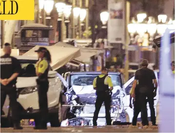  ?? MANU FERNANDEZ / THE ASSOCIATED PRESS ?? Police officers stand near the van involved in a terror attack on Las Ramblas in Barcelona on Thursday.