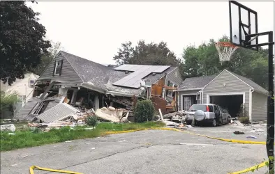  ?? Carl Russo / Associated Press ?? A house is destroyed in Lawrence, Mass., on Thursday after a series of gas explosions in the area. First-responders continued to fight at least 50 fires in Lawrence, Andover and North Andover Mass., Thursday. The fires are being attributed to problems with the natural gas system, and officials were urging residents to leave their homes if they smell gas.