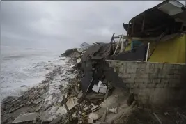  ?? PHOTOS BY JOHN RAOUX — THE ASSOCIATED PRESS ?? Parts of homes are seen collapsing on the beach Thursday in Wilbur-By-The-Sea, Fla.