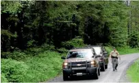  ?? AP ?? Washington State Fish and Wildlife Police leave the scene of a fatal mountain lion attack on a remote King County road in Washington State.