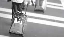  ?? Associated Press ?? A child pulls a suitcase along a crosswalk on Nov. 22 upon arriving at Hartsfield-Jackson Atlanta Internatio­nal Airport ahead of the Thanksgivi­ng holiday in Atlanta. Procrastin­ators may have already missed out on the best fares for Christmas travel,...