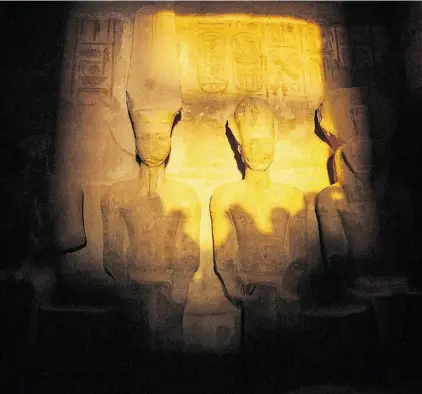  ?? MAHMOUD KHALED/AFP- Gett y Imag es ?? Twice a year, the rising sun illuminate­s the inner sanctuary of Ramses II’s Great Temple. On Feb. 22 and Oct. 22 — the king’s birthday and coronation — the morning rays bathe stone statues in shimmering light.