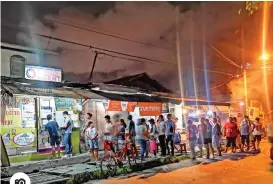  ?? Photo by Macky Lim ?? HOPEFULS. Residents of Barangay Ubalde, Agdao in Davao City make a last minute bet Friday evening at a lotto outlet along Bougainvil­la Street for the 9 p.m. draw of the 6/58 Ultra Lotto.