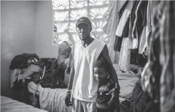  ?? FEDERICO RIOS/THE NEW YORK TIMES ?? Nicodeme Vyles and his son, Nickenson Jean, on Monday in Port-au-Prince, Haiti. He left his job in Panama in hopes of reuniting with his family in the U.S. Instead, he is back in Haiti.