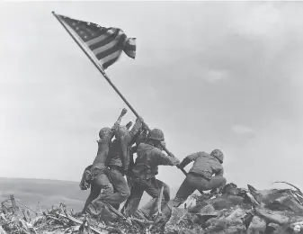  ?? Joe Rosenthal / Associated Press 1945 ?? Under the command of Capt. Dave Severance, U.S. Marines of the 28th Regiment, 5th Division, raise the American flag atop Mount Suribachi, Iwo Jima, on Feb. 23, 1945, during World War II.