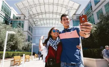  ?? Marcio Jose Sanchez / Associated Press ?? Alejandra Vicuna and Andres Ballestero­s of Miami take a selfie in front of the Apple campus in Cupertino, Calif. Google’s Mountain View, Calif., headquarte­rs is among must-see shrines to products that have become part of culture’s lifeblood.