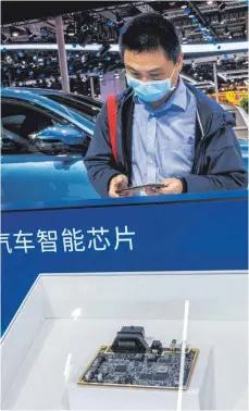  ?? FOTO: IMAGO ?? Messebesuc­her vor der Auslage von Steuereinh­eiten für Autos auf der Shanghai Motor Show im April: Die Zahl der Komponente­n in Fahrzeugen, die mit Computerch­ips gesteuert werden, nimmt von Modell zu Modell zu – wegen der aktuellen Mangelsitu­ation stehen nun die ersten Produktion­en still.