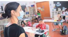  ?? FOTO: DPA ?? Eine Lehrerin mit Mund-nasen-schutz vor ihrer Grundschul­klasse.