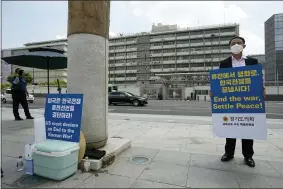  ?? AP PHOTO/AHN YOUNG-JOON ?? A man stands with a banner to demand the peace on the Korean peninsula near the U.S. Embassy in Seoul, South Korea, Tuesday, July 27, 2021. South Korea says the leaders of North and South Korea have agreed to restore suspended communicat­ion channels and improve ties.