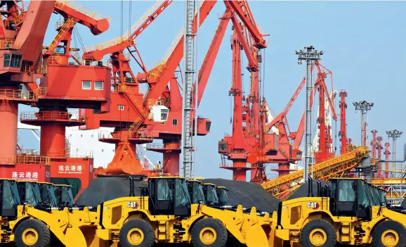  ??  ?? Lines of constructi­on machines wait to be shipped out and exported at a wharf of Lianyungan­g Port, Jiangsu Province, on May 7, 2020.