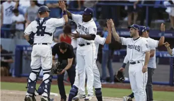  ??  ?? San Diego Padres catcher A.J. Ellis, left, celebrates with a Jose Pirela during final, ninth inning of a baseball game against Los Angeles Dodgers on Sunday, in Monterrey, Mexico. The San Diego Padres defeated the Los Angeles Dodgers 3-0. AP...