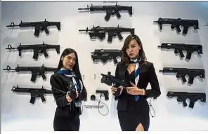  ?? — Bernama ?? All fired up: Two assistants of the Polish Armaments Group showing the weapons on display at the Defence Services Asia and National Security Asia exhibition 2018 in Kuala Lumpur.