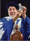  ?? ?? Southern Connecticu­t State University President Joe Bertolino shows off a memento he was given at the undergradu­ate commenceme­nt at the Total Mortgage Arena in Bridgeport Friday.