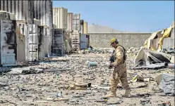  ?? AFP ?? A member of the Taliban Badri 313 military unit walks amid debris, in Kabul on Monday.