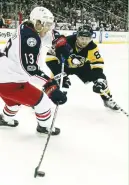  ?? (Reuters) ?? COLUMBUS BLUE JACKETS right wing Cam Atkinson (left) handles the puck against Pittsburgh Penguins right wing Phil Kessel (right) during the third period in Pittsburgh on Friday. The Penguins won 4-3 in overtime.