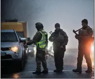  ?? AP/EVGENIY MALOLETKA ?? Ukrainian soldiers and police stop a car Tuesday at a checkpoint near the city of Mariupol, on the coast of the Sea of Azov. Coastal areas are subject to the martial-law declaratio­n the Ukrainian government plans to impose today.