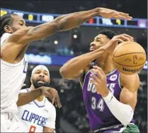  ?? Morry Gash Associated Press ?? BUCKS FORWARD Giannis Antetokoun­mpo has the ball knocked away by Kawhi Leonard, who missed a late jumper.